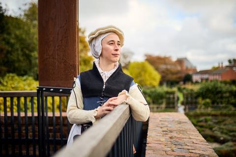 A woman dressed in a Shakespearean costume looks out across Stratford-upon-Avon