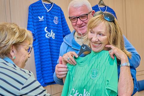 A lady poses with a football shirt as part of an Everton Football Club Stadium Tour