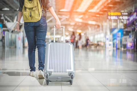 Wheeling suitcase in airport