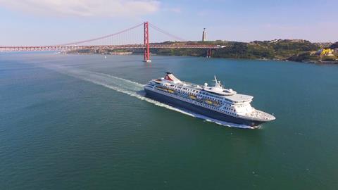 Fred. Olsen's cruise ship, Balmoral, sailing under the 21 De Abril Bridge in Lisbon, Portugal