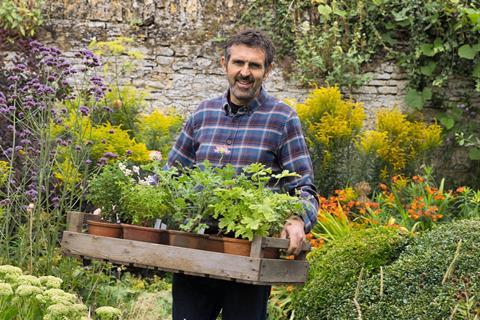 Gardeners' World presenter Adam Frost in a garden.