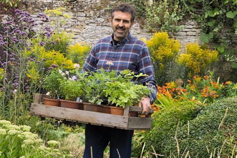 Gardeners' World presenter Adam Frost in a garden.