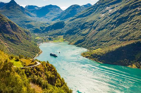 A cruise boat navigates the stunning fjords in Norway