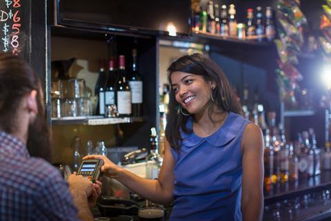 Customer paying by credit card machine in a pub