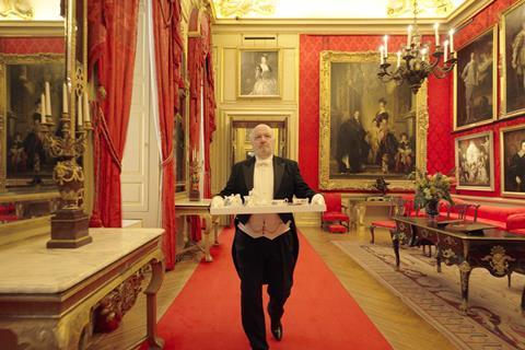 A butler carrying a tray through a room in Blenheim Palace