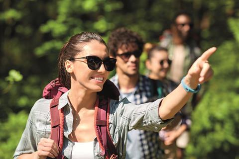 Group of friends walking with backpacks in forest