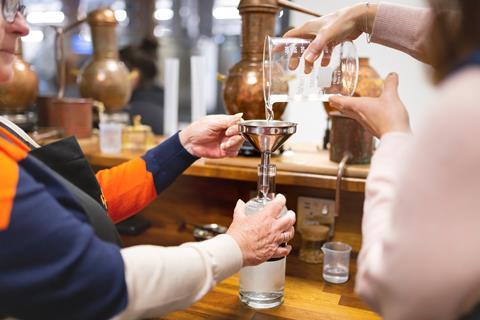 Pouring a spirit into a bottle at Hensol Castle Distillery