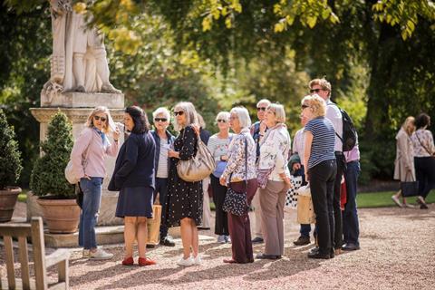 A group of visitors are guided around Chelsea Physic Garden in London