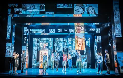 Screens showing social media clips about Evan Hansen behind the cast performing