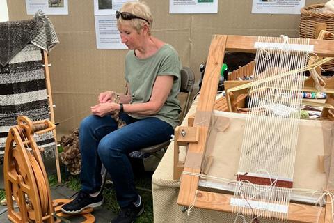 A woman weaves something at the Living Crafts Festival