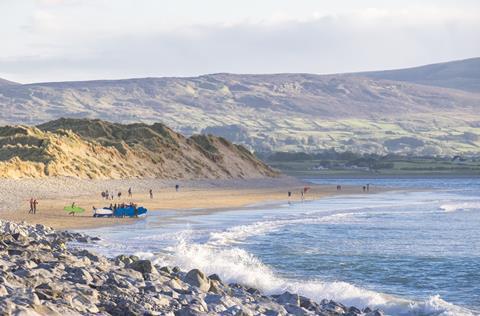 Surfers seen in the distance at Strandhill beach in County Sligo, Ireland