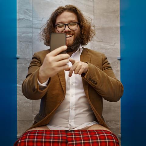 Man on the phone whilst on the toilet