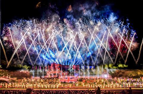 Firework display above crowd of performers