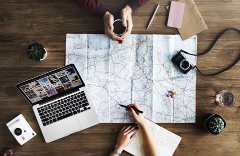 Travel planning with map and laptop