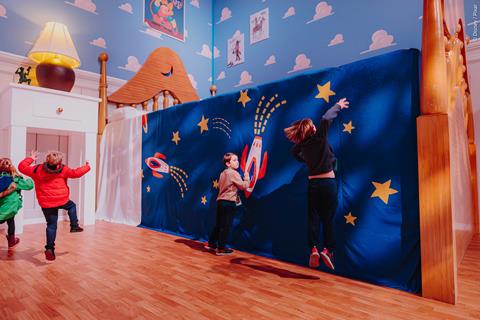 Children in an oversized recreation of Andy's room from Toy Story