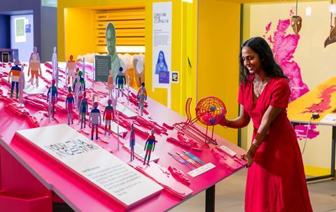 A woman looks at the We Go Way Back exhibition, touching different objects