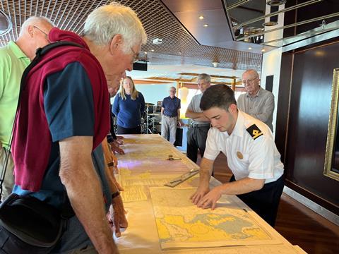 Cruise passengers look at navigational maps during Fred. Olsen Cruise Lines' behind the scenes tours