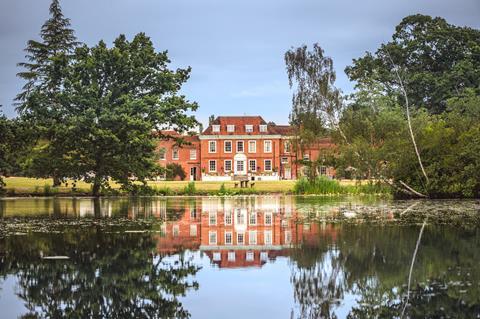 A red brick hotel by a lake