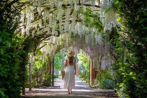 Woman walking through floral archway
